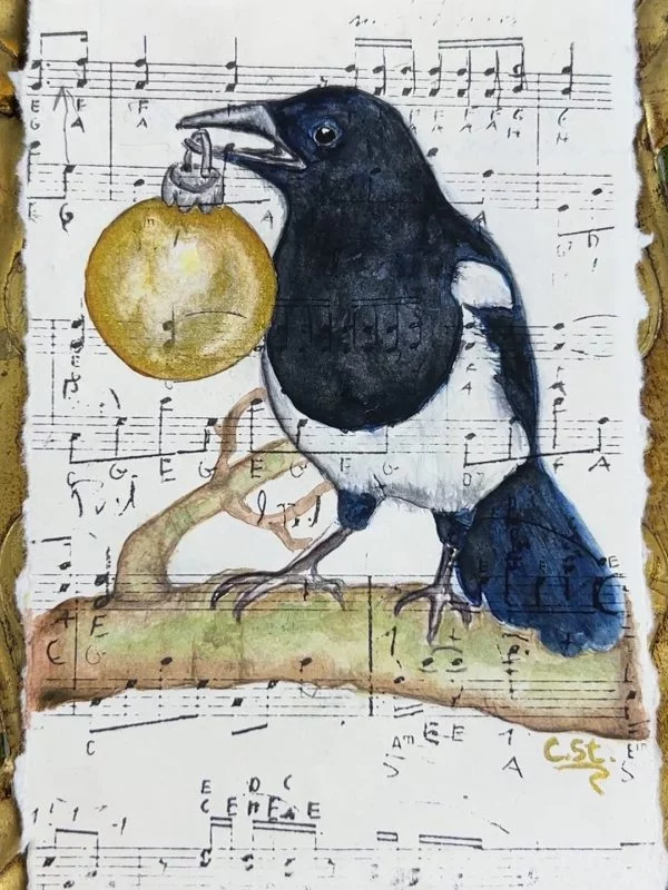 Hier findest du handgemalte Aquarelle - jedes ein Einzelstück.  Eine Elster sitzt vor zartem Notenpapier und hält eine goldene Weihnachtskugel im Schnabel. Zwischen Musik und Glanz entsteht ein Moment voller Ruhe, Magie und feiner Details.