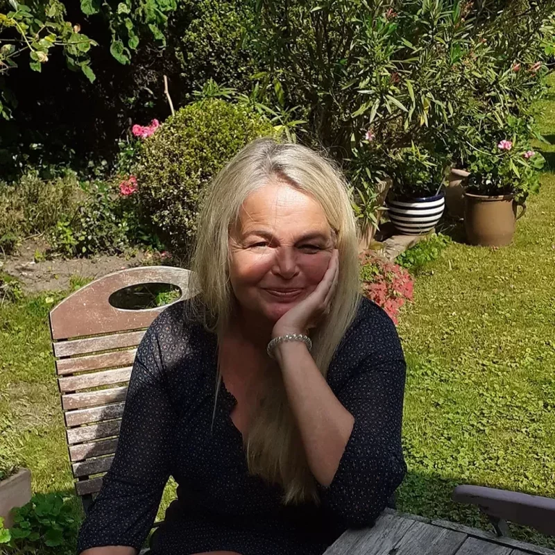 Claudia Stanitzeck, die Autorin im Garten, sie lächelt